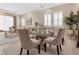 Dining area with chandelier, a glass-top table with seating, and large windows at 2400 Trissino Ct, Henderson, NV 89044