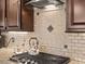 Gourmet kitchen features granite countertops, custom backsplash, and a gas cooktop at 2400 Trissino Ct, Henderson, NV 89044