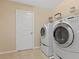 Functional laundry room with a full-size washer and dryer set and white wire shelving for storage at 2400 Trissino Ct, Henderson, NV 89044
