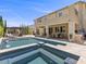 Amazing backyard boasts a pool with spa, outdoor kitchen, patio seating, and lounging area for relaxation and entertaining at 2400 Trissino Ct, Henderson, NV 89044