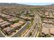An aerial view of a neighborhood with curved streets, desert landscaping, tile roofs, and mountain views at 2434 Quiet Ode St, Henderson, NV 89044