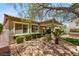 Spacious backyard with a covered patio, outdoor seating, desert landscaping, and well-maintained greenery at 2434 Quiet Ode St, Henderson, NV 89044