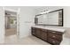 Modern bathroom featuring double vanity, large mirror and tile flooring at 2434 Quiet Ode St, Henderson, NV 89044