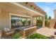 Relaxing covered patio with comfortable seating, a fire pit, and lush landscaping, creating a cozy outdoor space at 2434 Quiet Ode St, Henderson, NV 89044