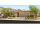 Inviting home featuring a well-kept lawn, desert landscaping, and a two-car garage at 2434 Quiet Ode St, Henderson, NV 89044