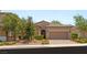 Charming single-story home with a well-manicured lawn, mature trees, and a two-car garage at 2434 Quiet Ode St, Henderson, NV 89044