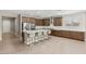 Bright kitchen boasts wood cabinets, stainless appliances, a center island with seating, and tile flooring at 2434 Quiet Ode St, Henderson, NV 89044