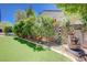 Backyard with artificial turf, stone fountain, stone wall and lush greenery at 2545 Nashira St, Henderson, NV 89044