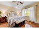 Cozy bedroom with hardwood floors, large window with white curtains, and neutral wall color at 2545 Nashira St, Henderson, NV 89044