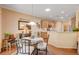 Dining area featuring a glass table with seating, view of kitchen and decorative mirror at 2545 Nashira St, Henderson, NV 89044