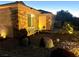 Evening exterior view of a home with stone accents, enhanced by landscape lighting at 2545 Nashira St, Henderson, NV 89044