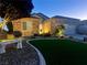 Charming front yard with stone accents, green grass, and a bench at 2545 Nashira St, Henderson, NV 89044