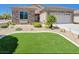 Manicured front yard featuring drought-resistant landscaping and a small patch of turf and cozy bench seating at 2545 Nashira St, Henderson, NV 89044