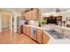 Open-concept kitchen featuring stainless steel appliances, wood cabinetry, and bar seating at 2545 Nashira St, Henderson, NV 89044