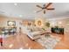 Open-concept living area featuring hardwood floors, ceiling fan, comfortable furniture and adjacent dining area at 2545 Nashira St, Henderson, NV 89044