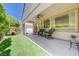 Covered patio with chairs and table overlooking the grassy backyard at 2545 Nashira St, Henderson, NV 89044