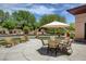 Outdoor patio featuring a dining table, chairs, umbrella, and lush desert landscaping at 2545 Nashira St, Henderson, NV 89044