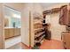 Walk-in closet with wood floors and ample shelving and hanging space with adjoining bathroom at 2545 Nashira St, Henderson, NV 89044