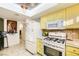 Bright kitchen with yellow cabinets, stainless steel appliances, and tile flooring at 27 Sirnoble St, Las Vegas, NV 89110