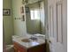 Small bathroom with a wood vanity cabinet and decorative mirror at 2700 W Prospector Ln, Pahrump, NV 89048