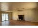 Living room with hardwood floors, brick fireplace, and large glass sliding doors for natural light at 2700 W Prospector Ln, Pahrump, NV 89048