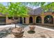 Courtyard view highlighting the architecture and desert landscaping, including mature trees and large planters at 2825 Burnham Ave, Las Vegas, NV 89169