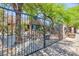 View of the front yard and home with mature trees, landscape design, and black metal fencing at 2825 Burnham Ave, Las Vegas, NV 89169