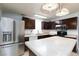 Bright kitchen featuring stainless steel appliances, dark cabinets, tile countertops, and decorative pendant lighting at 2825 Burnham Ave, Las Vegas, NV 89169