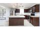 A cozy kitchen showcasing dark wood cabinets, a stainless steel refrigerator, and a functional center island at 2825 Burnham Ave, Las Vegas, NV 89169