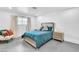 Cozy bedroom featuring a blue bed, light gray walls, a window, and a bedside table with a lamp at 3189 Montecito Dr, Las Vegas, NV 89120