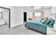 Bright bedroom featuring a blue bed, light gray walls, a window, and an open doorway to a bathroom at 3189 Montecito Dr, Las Vegas, NV 89120