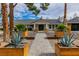 Beautiful front exterior of home with a paved walkway, xeriscaping, and mature landscaping at 3189 Montecito Dr, Las Vegas, NV 89120