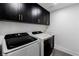 Well-equipped laundry room with modern washer and dryer, and black cabinets for storage at 3189 Montecito Dr, Las Vegas, NV 89120