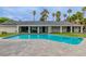A luxurious pool with a view of the home's backyard, palm trees, and outdoor dining area at 3189 Montecito Dr, Las Vegas, NV 89120