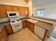 Cozy kitchen features wood cabinetry, white appliances, and durable countertops for easy maintenance at 3354 Indian Shadow St # 203, Las Vegas, NV 89129