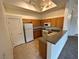 Functional kitchen featuring white appliances, wood cabinetry and granite countertops at 3354 Indian Shadow St # 203, Las Vegas, NV 89129