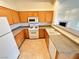 Bright kitchen with wood cabinets, granite countertops, tile floors and white appliances at 3354 Indian Shadow St # 203, Las Vegas, NV 89129