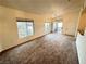 This bright, carpeted living room features two windows and a glass door that leads to an outdoor patio at 3354 Indian Shadow St # 203, Las Vegas, NV 89129