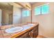 Bathroom with dual sinks, tile countertops, a large mirror, and a window at 3434 Toquima Cir, Las Vegas, NV 89120