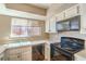 Efficient kitchen with light countertops, dark appliances, and a window providing natural light at 3434 Toquima Cir, Las Vegas, NV 89120