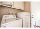 Amana washing machine and dryer in the laundry room with white cabinets above at 3434 Toquima Cir, Las Vegas, NV 89120