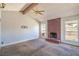 Spacious living room featuring a vaulted ceiling, brick fireplace, and ample natural light at 3434 Toquima Cir, Las Vegas, NV 89120