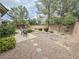 Landscaped backyard with decorative rocks, a walkway, bushes, trees, and a brick wall at 3476 Ridge Meadow St, Las Vegas, NV 89135