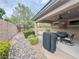 Charming backyard featuring a covered patio, grill, manicured landscaping, and decorative rock at 3476 Ridge Meadow St, Las Vegas, NV 89135