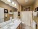 Well-lit bathroom featuring double sinks, a large mirror, and a shower with a curtain at 3476 Ridge Meadow St, Las Vegas, NV 89135