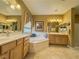Well lit main bathroom featuring dual sinks, soaking tub and vanity at 3476 Ridge Meadow St, Las Vegas, NV 89135