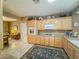 Efficient kitchen with wooden cabinets, built-in appliances, and an adjacent breakfast nook at 3476 Ridge Meadow St, Las Vegas, NV 89135
