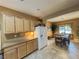 Spacious kitchen with wood cabinets, granite countertops, and access to an adjacent dining area at 3476 Ridge Meadow St, Las Vegas, NV 89135