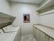 The laundry room has a washer, a dryer, storage cabinets, and a shelf for supplies at 3476 Ridge Meadow St, Las Vegas, NV 89135