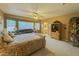 This spacious primary bedroom boasts a lounge area, ceiling fan, and adjoining bathroom at 3476 Ridge Meadow St, Las Vegas, NV 89135